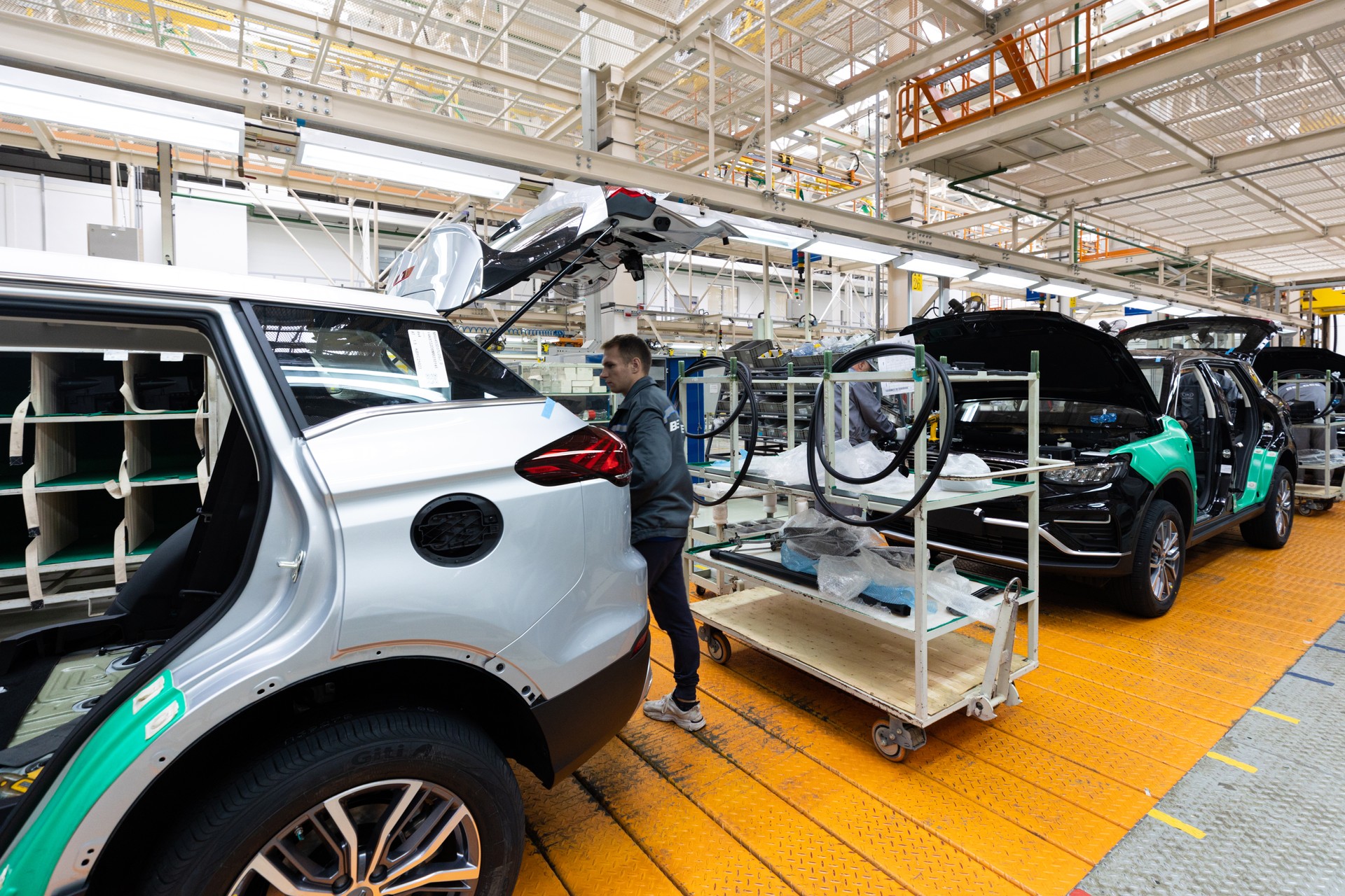 Minsk, Belarus - Dec 15, 2021: Car bodies are on assembly line. Factory for production of cars. Modern automotive industry. Electric car factory, conveyor