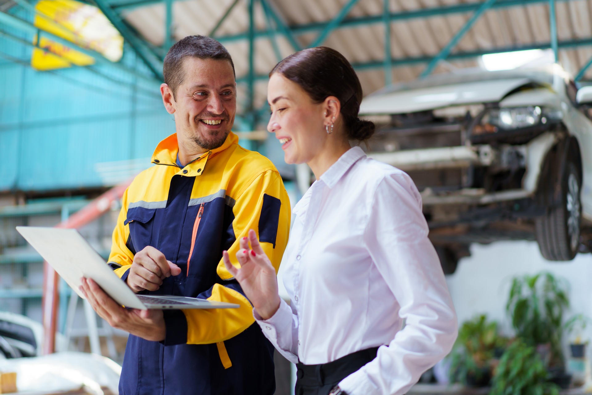 Vehicle technician talking with female customer.